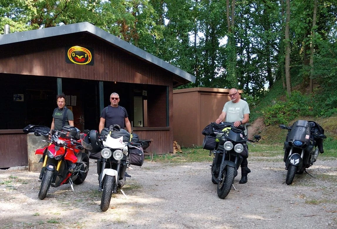 Drei Motorradfreunde mit ihren Motorrädern vor dem OMF-Clubhaus direkt nach der Rückkehr von einer 3.100-Kilometer-Tour